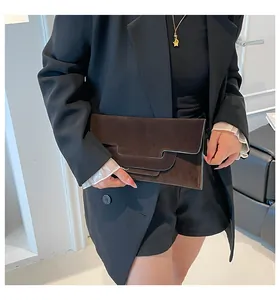Detailed view of a dark brown suede envelope clutch with asymmetric geometric flap