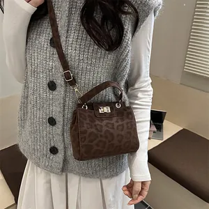 Detail of a chic leopard print small crossbody bag with gold-tone twist lock and shoulder strap
