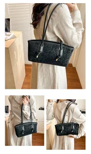Dettaglio borsa shopper nera leopardata con spalline annodate e pendenti in metallo dorato