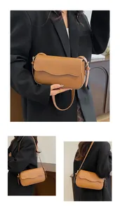 Détail d'un sac à bandoulière marron avec bord ondulé et bandoulière réglable