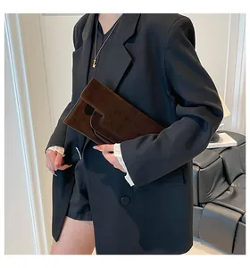 Minimalist dark brown suede envelope clutch bag shown in a professional fashion styling