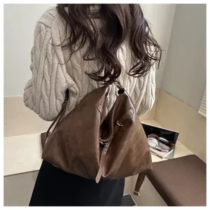 Detailed close-up of dark brown vintage faux leather tote with textured surface on a model