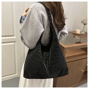 Detalle de bolso tote grande con estampado de leopardo en tela de terciopelo negro suave