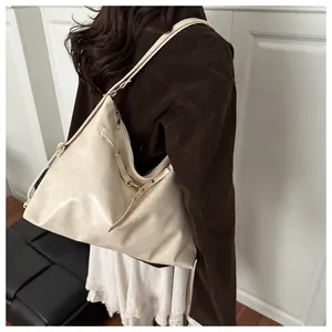 Model view of cream white large tote bag with soft leather texture and golden hardware