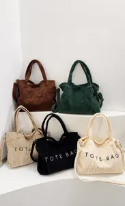 Detail of five corduroy tote bags in various colors featuring TOTE BAG embroidery