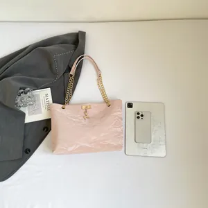 Light pink pleated tote bag with golden deer charm and chain strap for daily commute