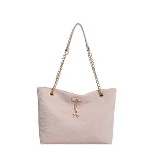 Elegant pale pink tote bag with gold chain strap and deer pendant on white background