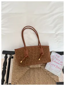 Macro shot of brown leopard print tote bag with gold metal accents on wicker chair