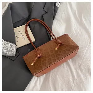 Detail of leopard print suede and brown leather tote bag with gold metal hardware knots