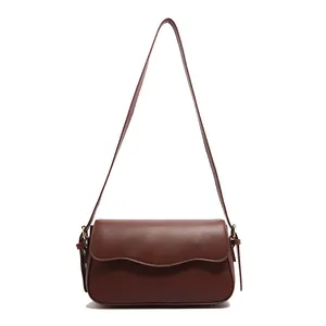 Sac bandoulière marron foncé minimaliste avec rabat ondulé et détails en métal doré