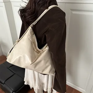 Retro cream white large tote backpack with gold hardware shown on a model's shoulder
