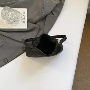 Top view of minimalist black nylon underarm bag interior showing zipper and soft lining