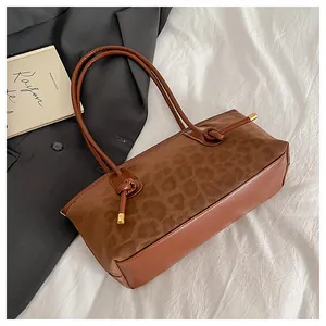 Detail of leopard print suede shoulder bag with leather straps and gold metal accents