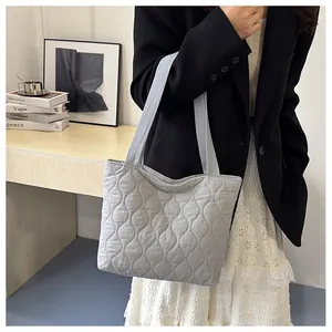 Quilted tote bag detail showing wave stitching and soft texture on light blue fabric