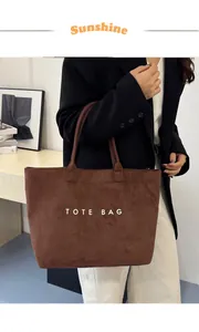 Gros plan du sac cabas en daim marron avec lettres imprimées et texture de suède doux