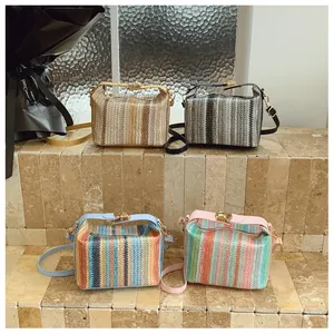 Detail of four colorful woven straw crossbody bags with metal clasps and leather straps