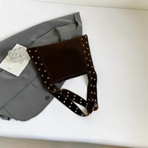 Détails d'un sac cabas en velours avec œillets métalliques et rivets argentés