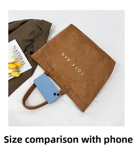 Sac fourre-tout en daim marron avec comparaison de taille par rapport à un smartphone