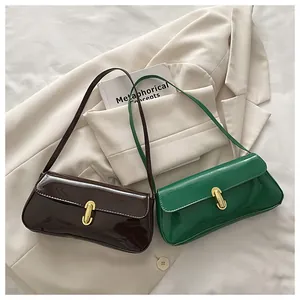 Detalle de bolsos de hombro en charol brillante marrón y verde con hebilla dorada en U