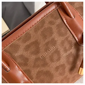 Macro detail of brown suede and leather texture with embossed GIHAIDI brand logo