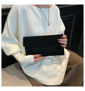 Detail of elegant black envelope clutch bag featuring a triple-layered flap design