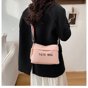 Bolso tote de pana rosa con bordado y correa ajustable mostrado por una modelo