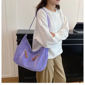 Detail view of purple corduroy crossbody bag texture and practical side zipper pocket
