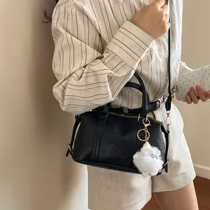 Schwarze Boston-Tasche mit Fashion Air Paris-Prägung und weißem Plüsch-Anhänger