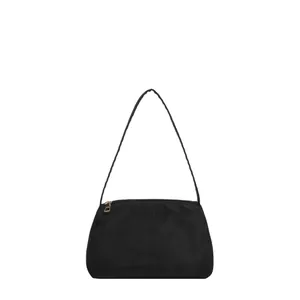Minimalist black nylon underarm shoulder bag with golden zipper and sleek trapezoid shape