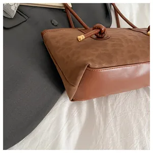 Detail of leopard print tote bag featuring smooth leather base and golden hardware