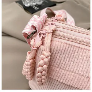 Detalle de bolso bandolera de pana rosa con cremallera tejida y costuras de precisión