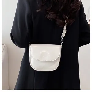 Detailed view of a white semi-circular saddle bag on black suit with silver hardware