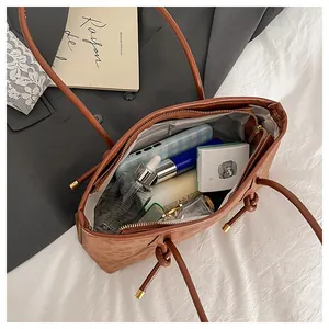 Interior view of brown faux leather tote bag showing spacious storage with zipper pocket
