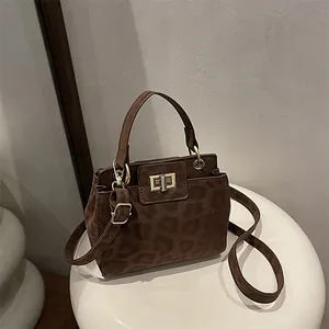 Brown leopard print crossbody bag with gold hardware buckle and adjustable strap