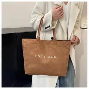 Gros plan d'un sac cabas en daim marron avec inscription TOTE BAG blanche pour le quotidien