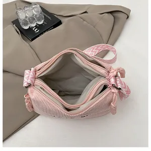 Bolso bandolera de pana rosa con tres bolsillos de cremallera y correa ancha de dibujo