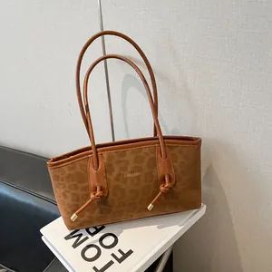 Retro brown leopard print tote bag with gold logo on a Tom Ford book for work