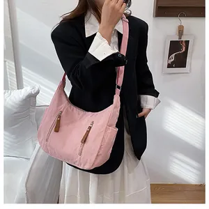 Pink corduroy crossbody bag featuring dual front zipper pockets and side slip design