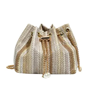 Minimalist straw woven bucket bag with zig-zag patterns and gold chain pearl drawstring