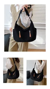 Detail of black corduroy crossbody bag showing texture, zippers and adjustable strap
