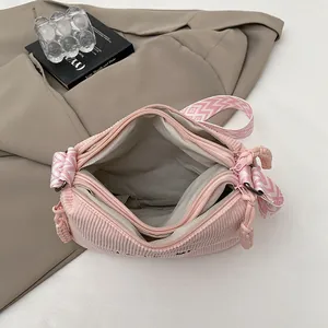 Bolso bandolera de pana rosa con dos compartimentos y correa de tejido geométrico