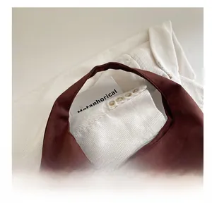 Détail du sac cabas en daim marron avec un design minimaliste en forme de croissant