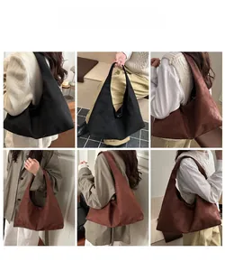 Mannequin portant un grand sac cabas en suédine noir et marron foncé pour un style polyvalent