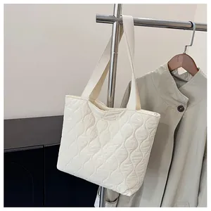 Close-up of beige quilted space cotton tote bag with wave pattern and wide handles