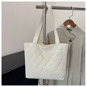 Close-up of off-white quilted tote bag with wavy stitching texture on nylon fabric