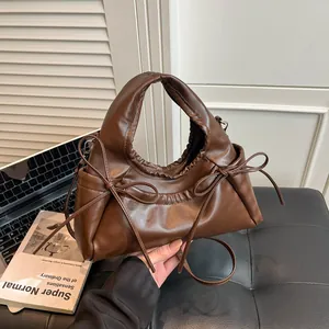 Deep brown pleated cloud tote bag with bow details and sleek adjustable shoulder strap