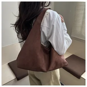 Détail de la texture en daim doux et style hobo spacieux de ce sac porté épaule marron