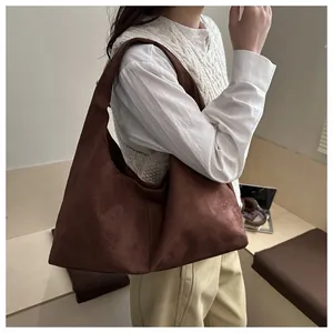 Détail d'un grand sac hobo en daim marron avec une texture douce et un style minimaliste