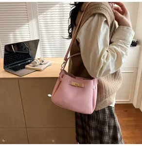 Detail of pink lychee grain bucket bag with gold twist lock and adjustable shoulder strap