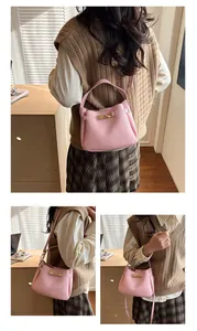 Detail of light pink pebble leather bucket bag featuring gold hardware and modular straps